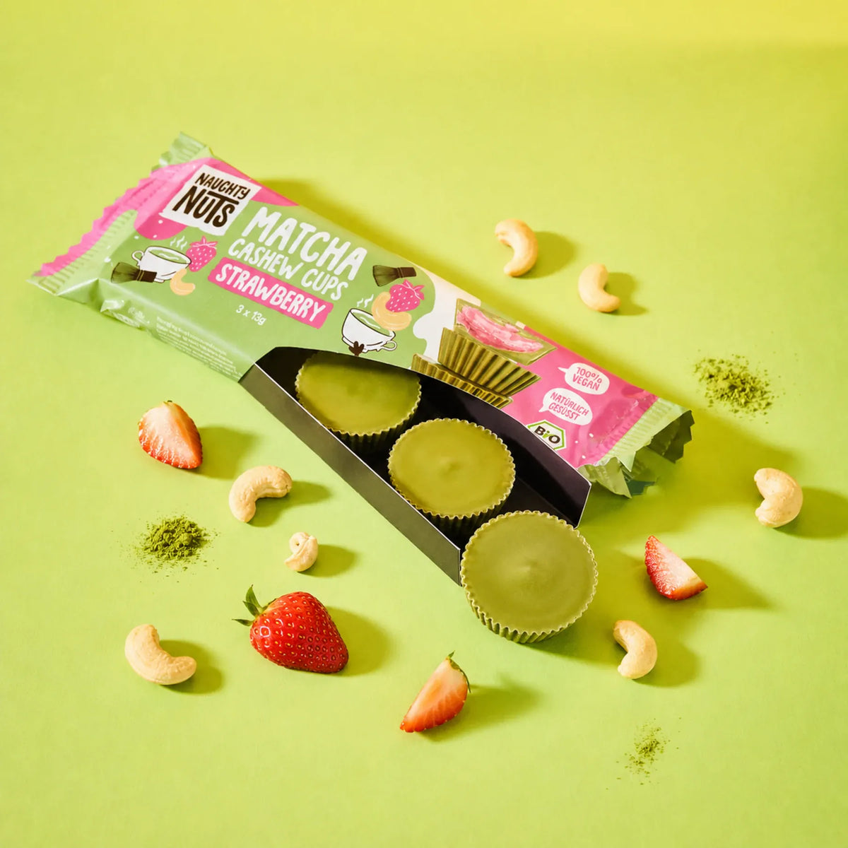 Matcha Cups Cashew Strawberry Packung mit drei grünen Matcha Cups, Erdbeeren und Cashewkernen