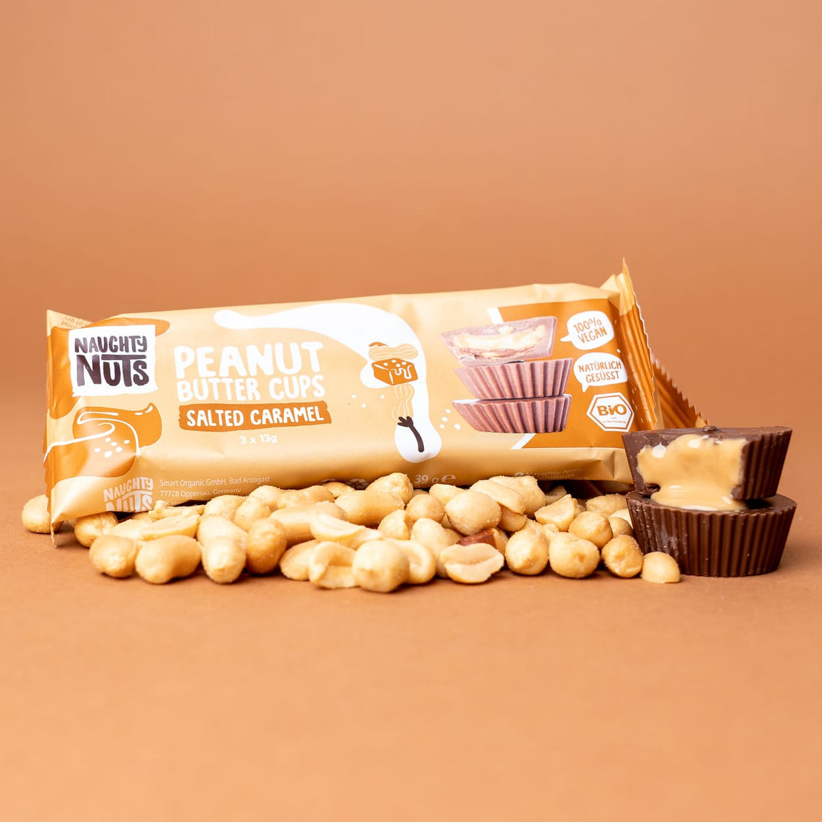 Bio Peanut Butter Cups Salted Caramel Packung mit Erdnüssen und zwei geöffneten Cups