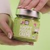 Happy Matcha Creme - Frau hält Matcha in der Hand und streicht es anschließend über ein Brot mit einem cremigen tropfen am ende